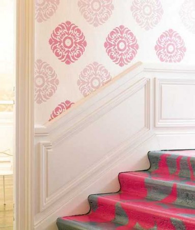 A pink and gray stairway with a creative pink wallpaper design.