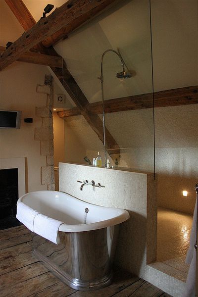 A bathroom with wooden beams and a bathtub transformed into a luxurious retreat.