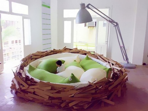 A bird nest bed in a whimsical kids room with a lamp.