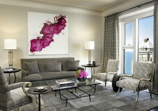 A living room with a large haute couture painting on the wall.