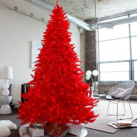 A vibrant red Christmas tree illuminates a cozy living room.