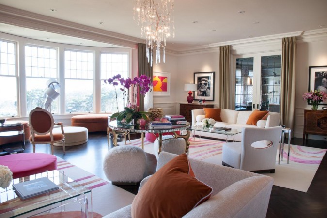 A living room with white furniture and pink haute couture accents.