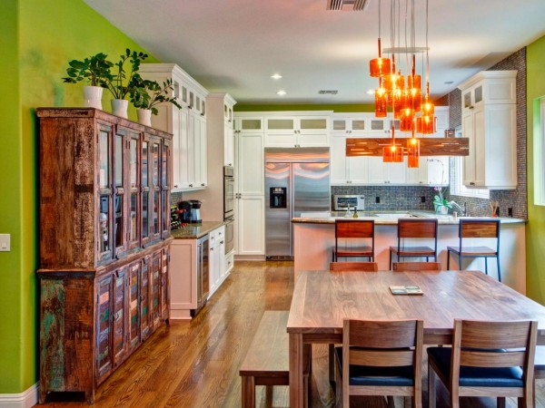 Beautiful pendant lights and colorful walls highlight this kitchen