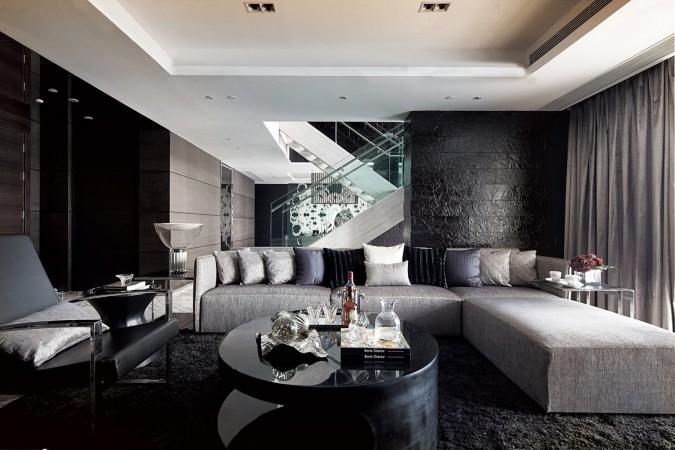 A black and white living room with a sleek staircase designed with Haute Couture touch.