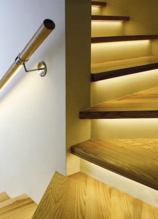 A staircase with a creative wooden railing.