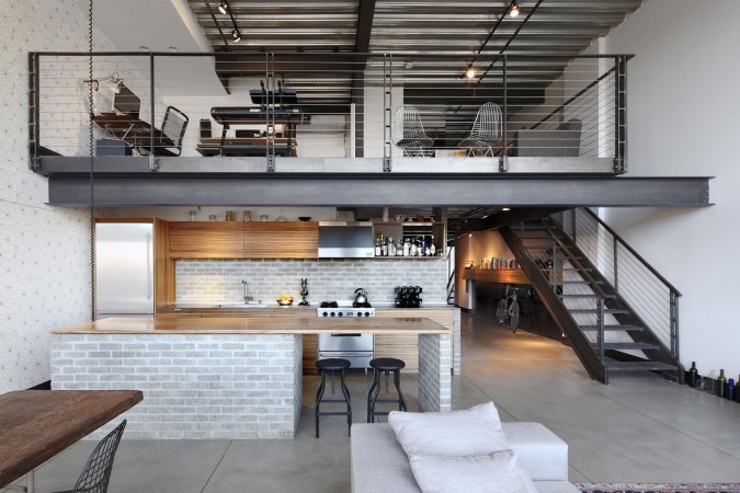 A masculine loft with industrial style, featuring stairs and a kitchen for the modern man.