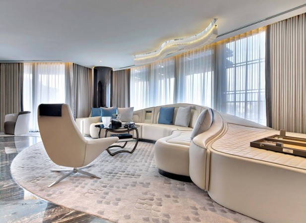 A modern living room with a curved sofa and chairs designed with haute couture interior design.