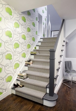 A creative staircase design with green and white wallpaper.