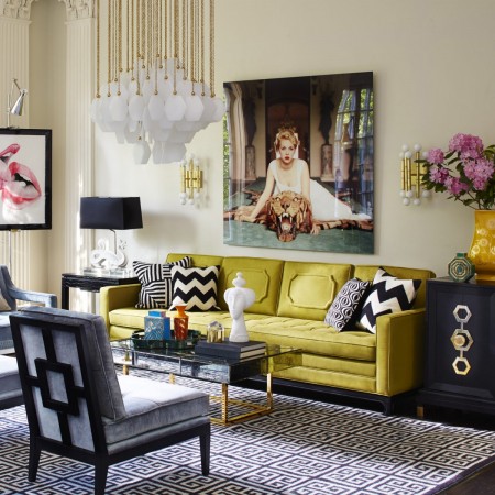A living room with a yellow couch and black chairs, designed by Jonathan Adler, the King of Happy Chic.