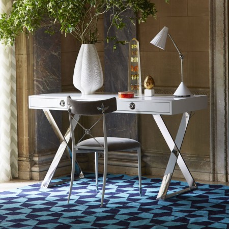 A desk in a room with a blue and white rug featuring Jonathan Adler's signature Happy Chic style.