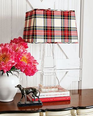 A lamp with a plaid shade on top of a dresser for a cozy home.