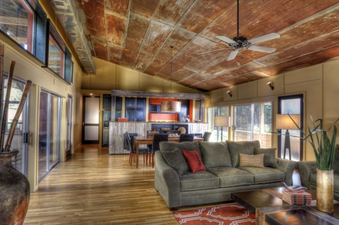 A living room with a wooden ceiling featuring corrugated metal accents.
