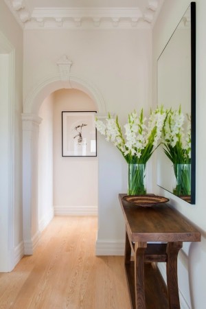 A hallway with white flowers and a wooden table.