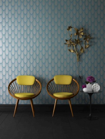 Two retro chairs in front of a vibrant blue wallpaper.