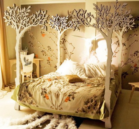 A kids bedroom with a canopy bed decorated with trees.