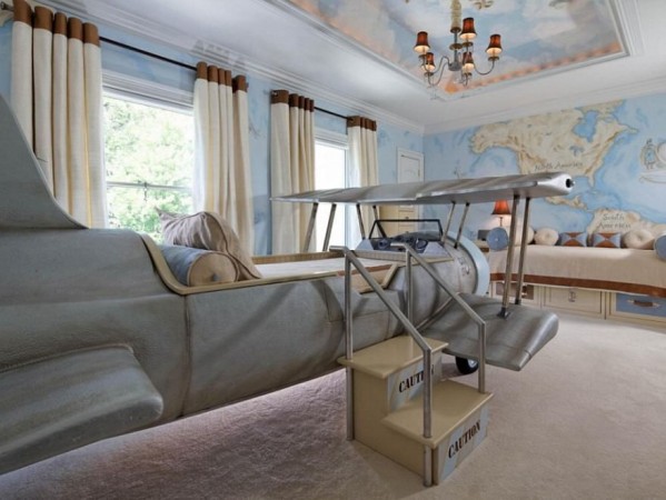 A kids room with an airplane bed and a map on the wall.