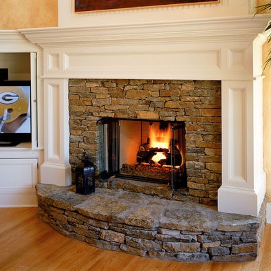 Painted wood mantel surrounds stone fireplace