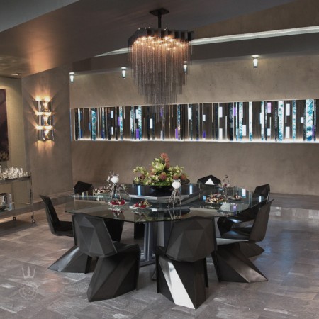 A haute couture dining room with a glass table and chairs.