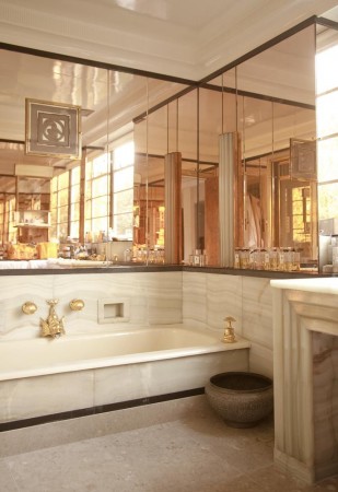 A bathroom with rose gold mirrors and a bathtub.