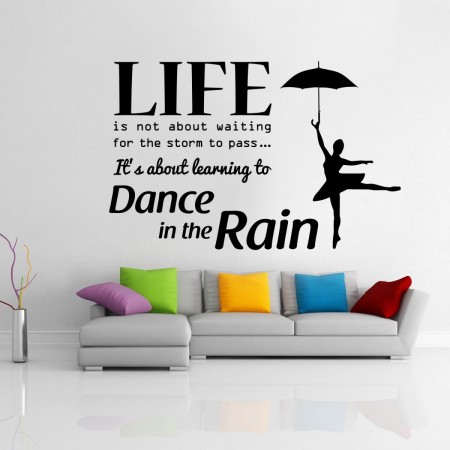 A living room with a wall stickers saying life is not waiting to dance in the rain.