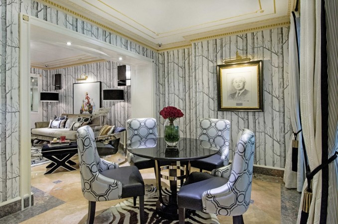 A dining room with haute couture interior design featuring zebra wallpaper and chairs.