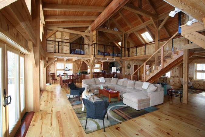 A living room with wood floors and a staircase featuring the beauty of lodge style interiors.