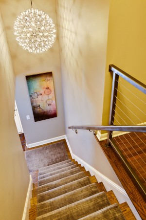 A staircase leading to a room with a painting on the wall featuring seven creative ways to design a stairwell.