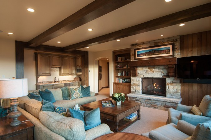A warm and inviting living room with wood beams and a fireplace.