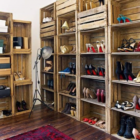 A closet full of wooden crates repurposed for shoe storage.