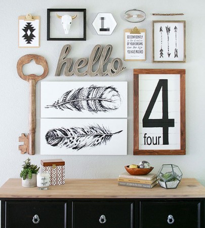 Create a unique gallery wall using a white dresser adorned with framed pictures, feathers, and a clock.