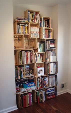 A room full of books on repurposed wood crates.