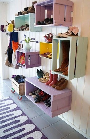 Colorful shoe racks on a wall in a hallway repurposed from wood crates.