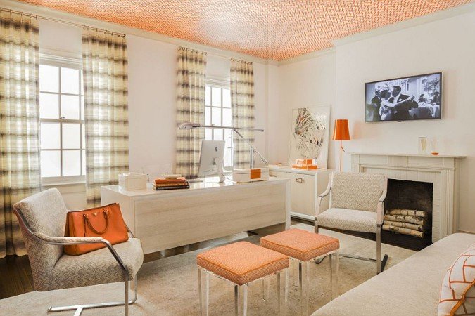 A stylish orange and white living room with a fireplace.