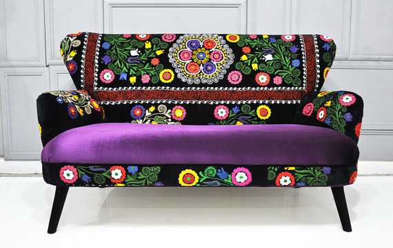 A vibrant purple couch with bold embroidered design.
