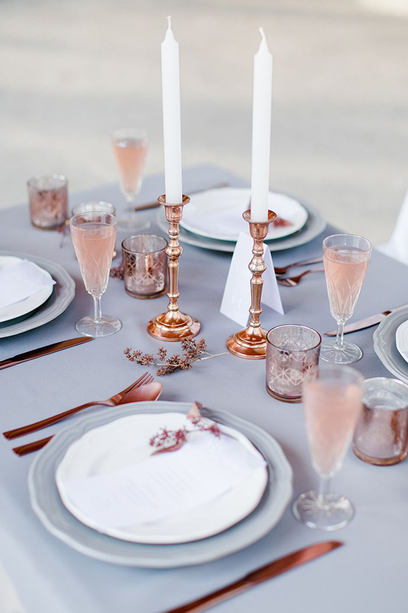 A table setting incorporating 2016's colors of the year, rose gold and grey plates and silverware.