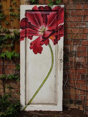 A repurposed door with a red flower on it.