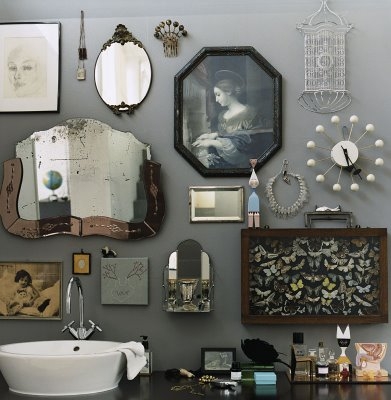 A unique gallery wall with mirrors and pictures in a bathroom.