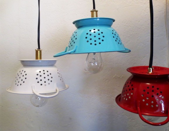 Three repurposed pendant lights hanging on a wall.