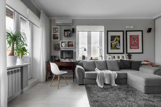 A warm and welcoming living room with a grey couch and white walls.