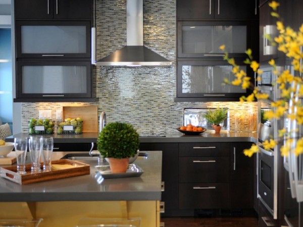 A kitchen with black cabinets, yellow flowers, and character.