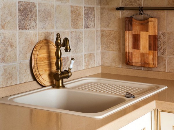 A kitchen sink with a wooden cutting board, adding character to your kitchen.