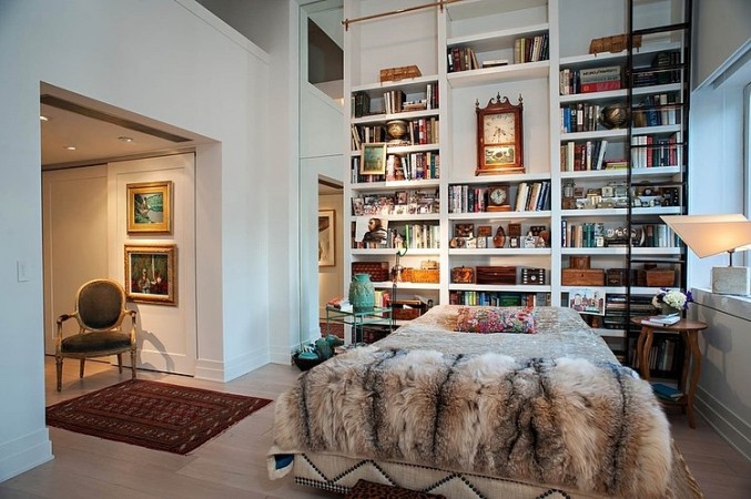 A stylish city apartment with a bed and bookshelves.