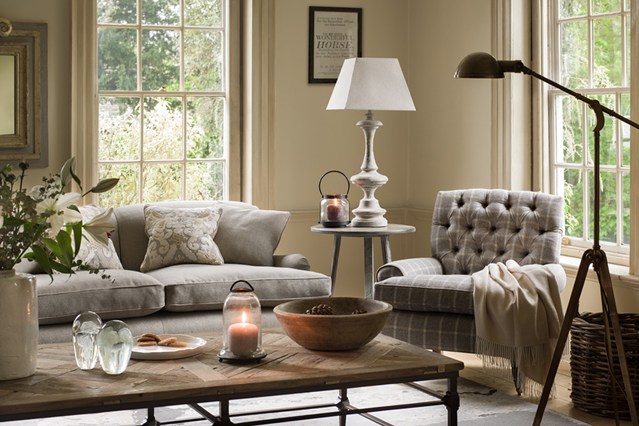 A warm and welcoming living room with winter-inspired grey furniture and a lamp.