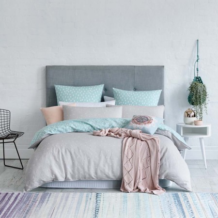 A bedroom showcasing 2016's Colors of the Year in a grey, pink, and blue duvet cover.