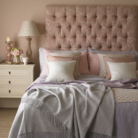 A bedroom featuring 2016's Colors of the Year for your interiors and a pink headboard and pillows.