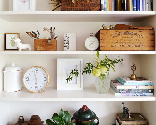 A white shelf with books and plants.