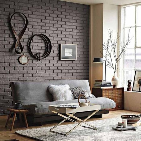 A living room with a unique grey brick wall.