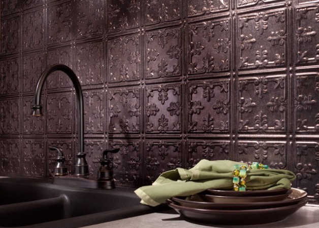 A kitchen with a sink and beautiful tin tiles on the wall.