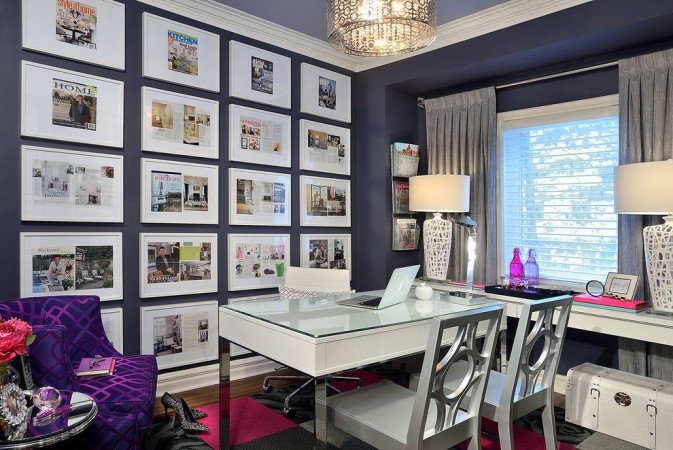 A stylish home office with lots of pictures on the wall.