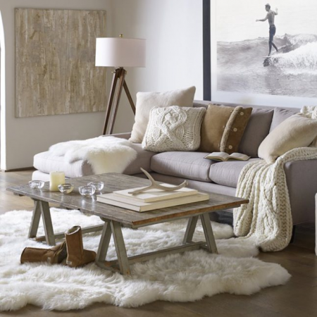 Warm and Welcoming Winter-inspired Living Room with a white couch and sheepskin rug.